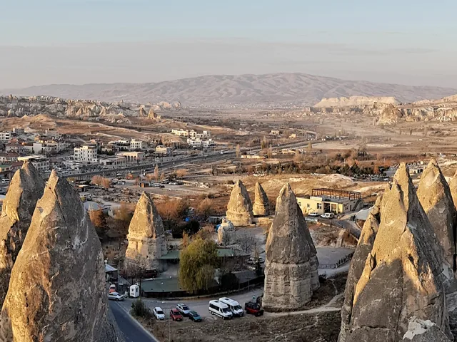 Göreme'de ön planda peribacaları, arkada kasabanın evleri ve vadiler